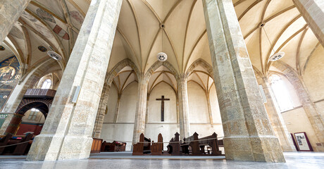 Fototapeta premium Inside a Emmaus Monastery featuring towering stone columns and an arched ceiling