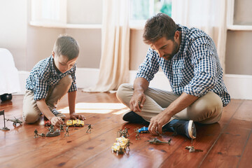 Dad, son and playing with toys on floor for bonding, activity or imagination at home. Father with...