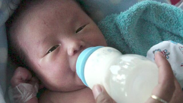 Footage Slow Motion: Baby boy drinking milk from milk bottle