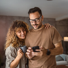 Portrait of adult couple husband and wife use mobile phone together