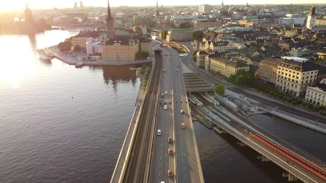 Cars and traffic on the central bridge road, Slussen and Gamla Stan, aerial view, late afternoon sun, old town and Riddarholmen. Summer in Stockholm, Sweden. Metro and railway