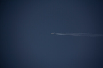 Airplane flight in the sky and the line that forms behind it (contrail)