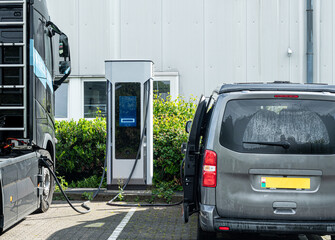 Zero emission 100% electric truck lorry and camper van plugged in on charge at a commercial charge station on an industrial estate