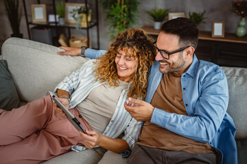 Adult couple use tablet at home have fun together