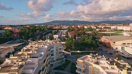 Aerial view sprawling cityscape illuminated morning sunlight. Modern buildings