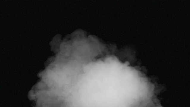 All-Filling Frontal Stream of Smoke. A stream of white smoke emerges from the darkness and moves straight into the camera, completely filling the screen with a white veil