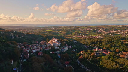 Aerial view historical town nestled in lush greenery under white fluffy clouds