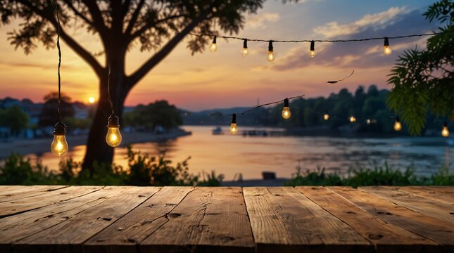 Empty Wood table top with decorative outdoor string lights hanging on trees in the revier nature  at sunset time,