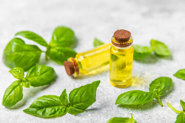 Basil essential oil on a textured wooden background. Basil essential oil and fresh leaves. Aromatherapy. Aroma oil. Medical herbs. Alternative medicine. Place for text. Copy space.