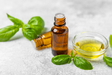 Basil essential oil on a textured wooden background. Basil essential oil and fresh leaves. Aromatherapy. Aroma oil. Medical herbs. Alternative medicine. Place for text. Copy space.