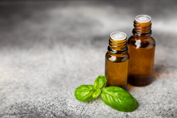 Basil essential oil on a textured wooden background. Basil essential oil and fresh leaves. Aromatherapy. Aroma oil. Medical herbs. Alternative medicine. Place for text. Copy space.