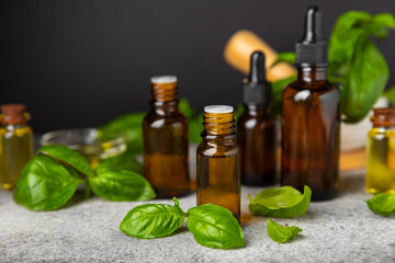 Basil essential oil on a textured wooden background. Basil essential oil and fresh leaves. Aromatherapy. Aroma oil. Medical herbs. Alternative medicine. Place for text. Copy space.