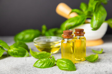 Basil essential oil on a textured wooden background. Basil essential oil and fresh leaves. Aromatherapy. Aroma oil. Medical herbs. Alternative medicine. Place for text. Copy space.