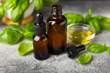 Basil essential oil on a textured wooden background. Basil essential oil and fresh leaves. Aromatherapy. Aroma oil. Medical herbs. Alternative medicine. Place for text. Copy space.