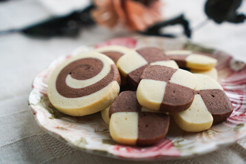 背景にバラを置いたチョコとバニラのアイスボックスクッキー