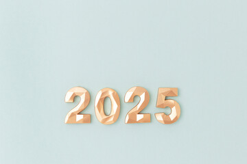 2025 - golden numbers on a blue background. New Year composition with copy space.