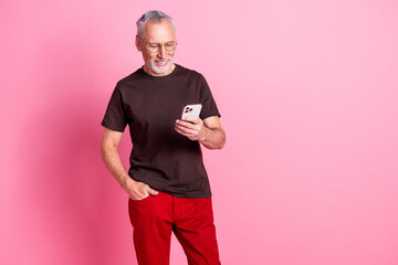 Portrait of smart man with beard dressed t-shirt in glasses read email on smartphone arm in pocket...