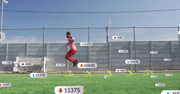 Image of multiple notification bars over biracial soccer player doing jumping drill before match