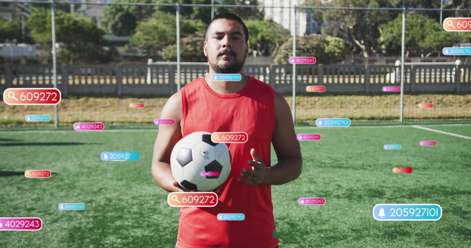 Image of notification bars over smiling biracial player juggling soccer ball on ground - Powered by Adobe