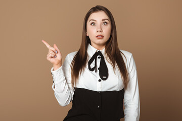 Surprised Young Woman Pointing Up. Expressive Gesture of Amazement. Copy Space for Text