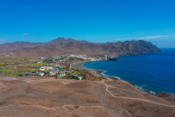 A breathtaking view of the town Las Playitas nestled between rugged mountains and the azure Atlantic. This stunning Fuerteventura landscape captures the essence of the Canary Islands' unique beauty.