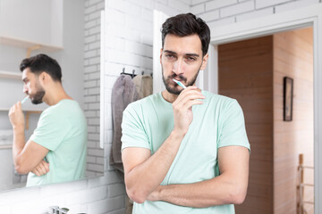 Fototapeta premium Handsome man brushing teeth in the bathroom 