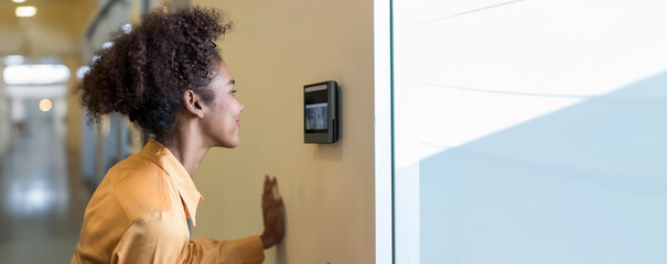 Woman using face scanner to unlock door in office building. Access control facial recognition system. Biometric admittance control device for security system. Biometric admittance control device.
