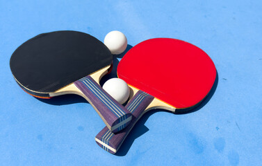 Two rackets for ping-pong on a blue table.