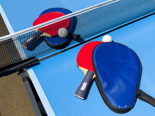 Two rackets for ping-pong on a blue table.