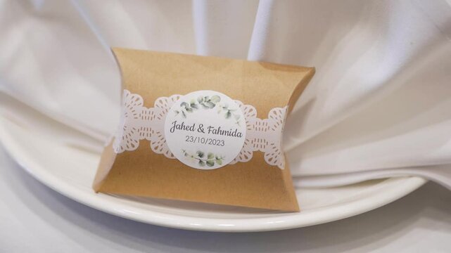 A beautiful shot of a monogrammed wedding favor box placed on the table for guests.