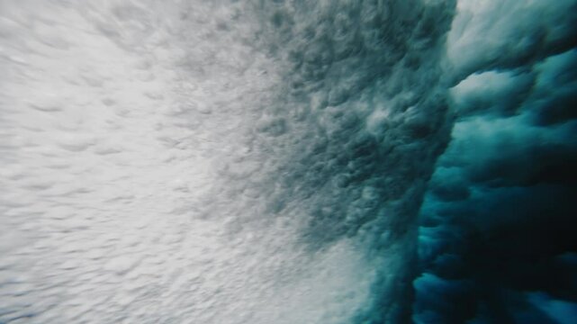 Underwater shallow textured air bubbles roll in mystic ocean texture from wave breaking at Cloudbreak Fiji