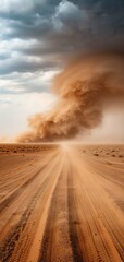 Dramatic image of a swirling sandstorm over an empty desert road under a cloudy sky, capturing the raw power of nature.