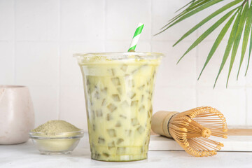 Cold green matcha latte drink.  Delicious iced matcha green tea mixed with ice cubes and whipped...