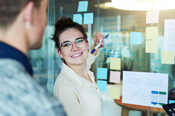 Woman, writing and brainstorming with sticky notes for project, presentation or collaboration as team. Business people, office and discussion for idea, planning as group in creative agency for career