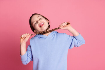 Portrait of cute little schoolkid braids choke neck wear hoodie isolated on pink color background