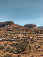 Breathtaking landscape photograph of Ghost Ranch in New Mexico, showcasing the vibrant red rock formations and expansive desert scenery. 