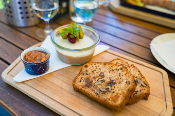 Duck liver pate appetizer with fruit and nut cake in a Czech restaurant served on a wooden board