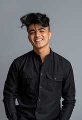 Obraz premium A young and handsome Indian male model in his early 20s, smiling at the camera, wearing a high collar colorful shirt, in a head and shoulder studio portrait with a light grey background