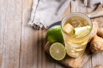 Fresh ginger ale drink in tall glass on wooden table. Copy space