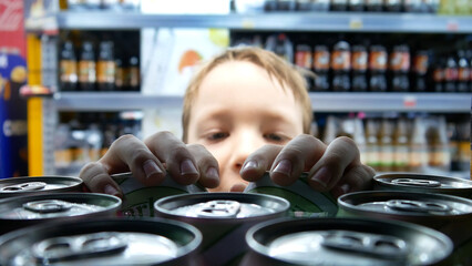 A boy taking two sweet soda cans in a grocery store