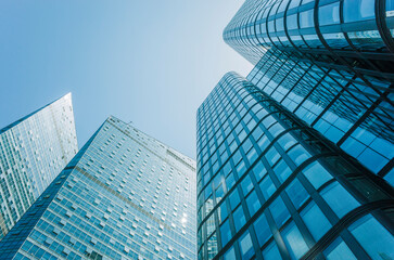 Low angle view of skyscraper with glass window and clear blue sky background for business and...