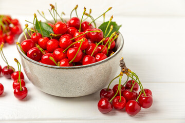 Cherries. Fresh ripe cherries with leaves on a textured wooden background. Fresh sweet organic cherry pile. Berries and fruits. Vegan. Healthy eating. Place for text. Copy space