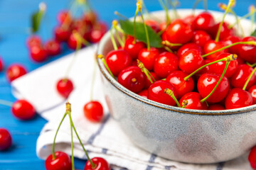 Cherries. Fresh ripe cherries with leaves on a textured wooden background. Fresh sweet organic cherry pile. Berries and fruits. Vegan. Healthy eating. Place for text. Copy space