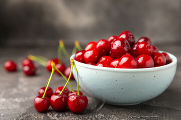 Cherries. Fresh ripe cherries with leaves on a textured wooden background. Fresh sweet organic cherry pile. Berries and fruits. Vegan. Healthy eating. Place for text. Copy space