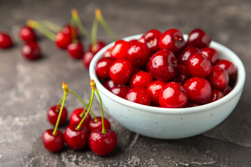 Cherries. Fresh ripe cherries with leaves on a textured wooden background. Fresh sweet organic cherry pile. Berries and fruits. Vegan. Healthy eating. Place for text. Copy space