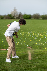 Young guy on a filed with a golf stick