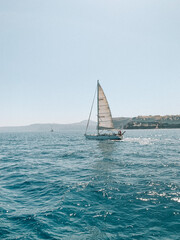 Obraz premium Serene photograph of a boat gliding across the Aegean Sea near Santorini, Greece