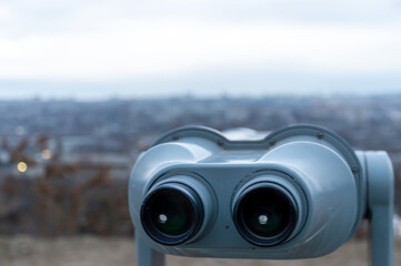 A pair of binoculars focused on a cityscape with buildings in the background