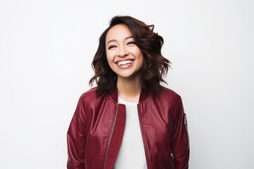 Portrait of a blissful woman in her 30s wearing a trendy bomber jacket while standing against white background