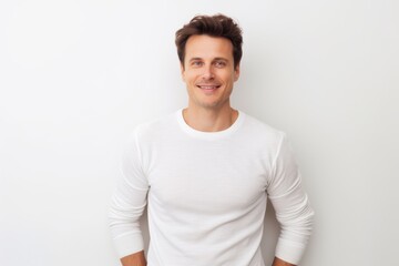 Obraz premium Portrait of a tender man in his 30s showing off a thermal merino wool top on white background